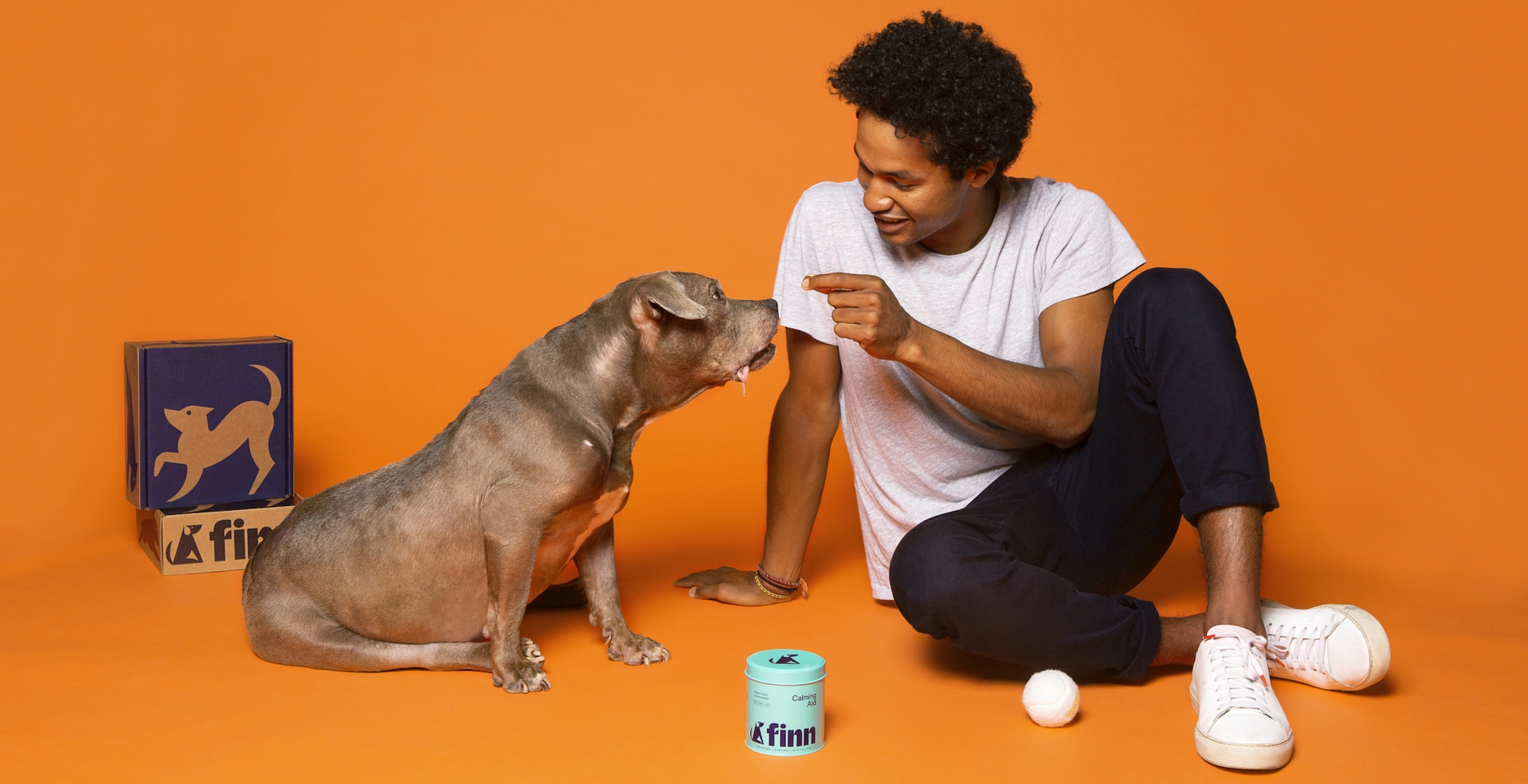 Man feeding Finn supplement to sitting dog